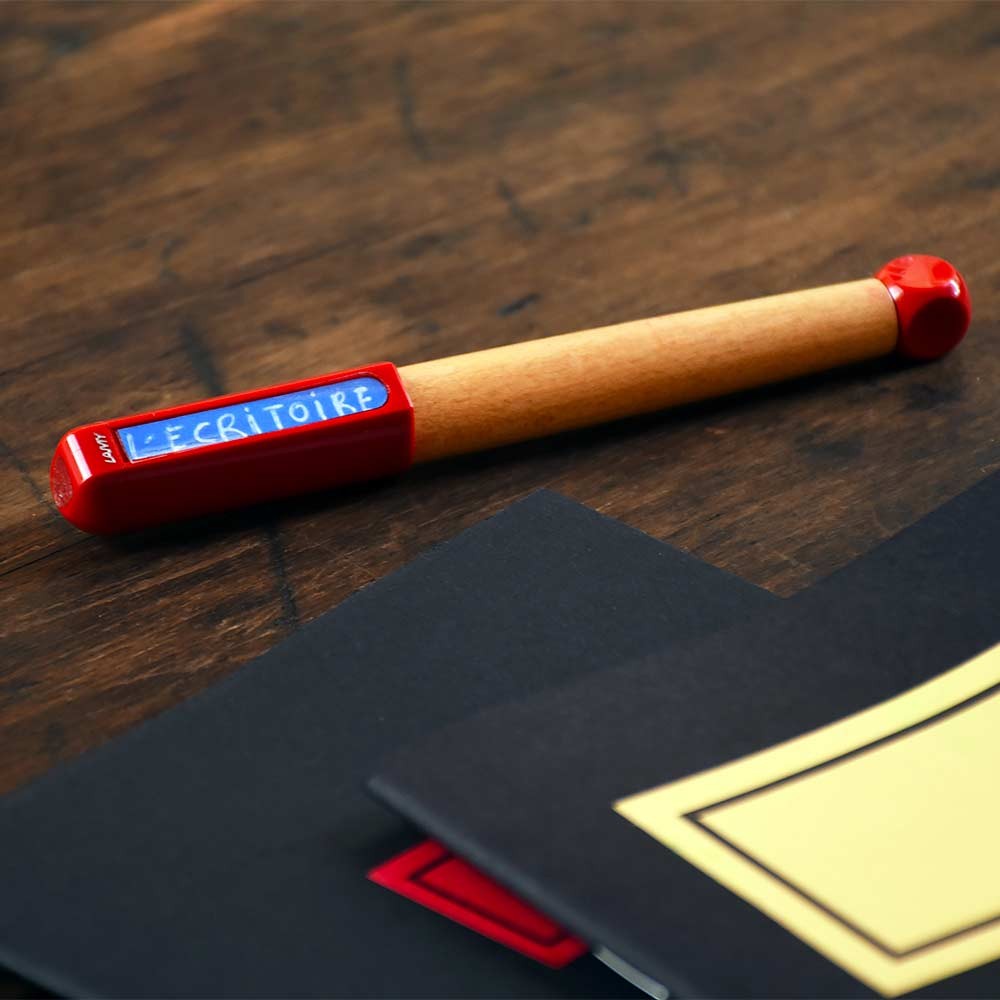 Niebieskie pióro wieczne z ergonomicznymką i przezroczystym korpusem leży na białym tle