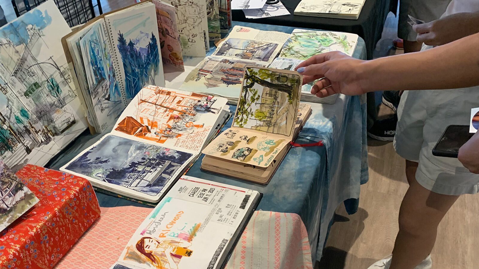 Otwarty szkicownik z czarnymi kartkami i rysunkami białym żelem fluorescencyjnym