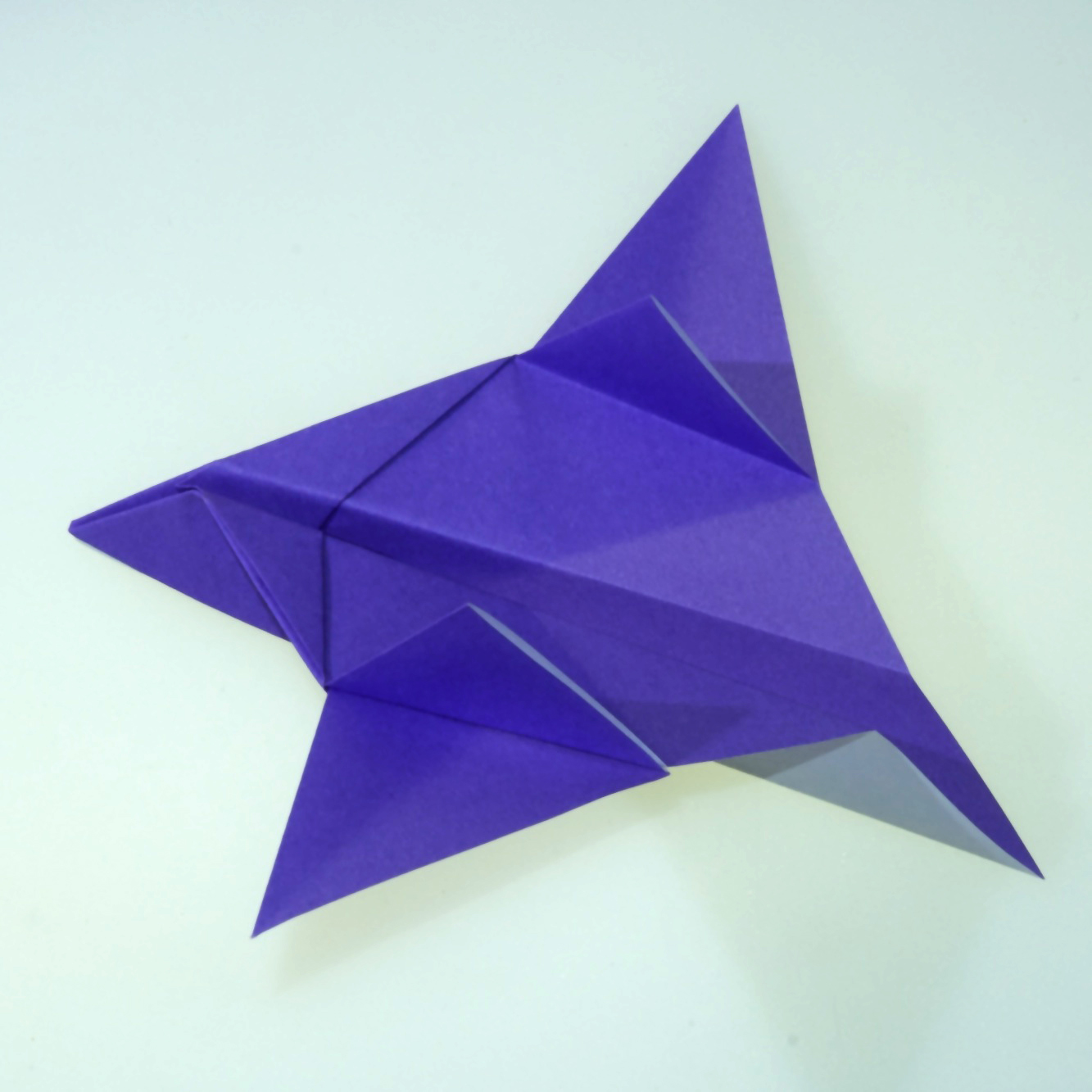 samolot origami z kolorowego papieru czerwono-biały papierowy samolot origami na stole